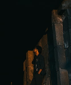 Photo of Man Leaning on Wall at Night-time thumbnail