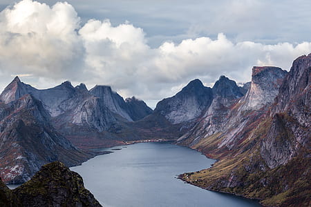mountains near body of water under blue sky thumbnail