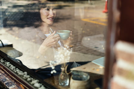 woman holding blue ceramic mug during daytime thumbnail
