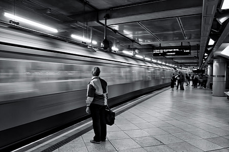 A passenger waits for the arriving train on the platform of the London Underground rail network thumbnail