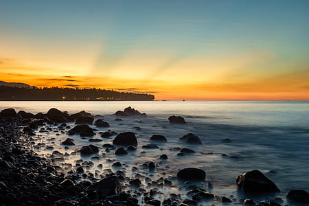 large boulders on shore at dusk thumbnail