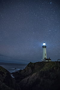 lighthouse under starry night wallpaper thumbnail