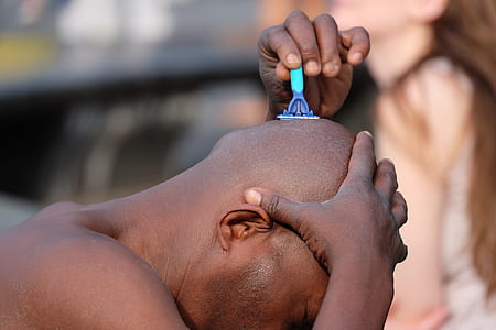 focus photography of man shaving hair on head thumbnail