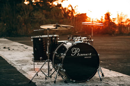 Planet drums on gray pathway during golden hour thumbnail