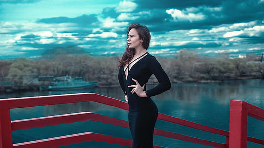 woman in black long-sleeved dress standing beside red hand rail thumbnail