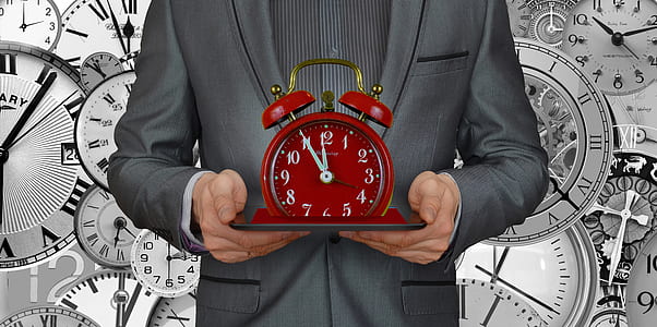 person holding red alarm clock thumbnail