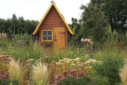 brown wooden playhouse near trees and grasses at daytime thumbnail