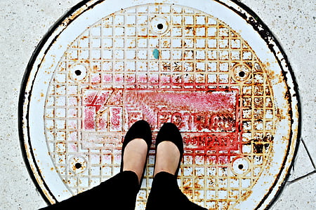 person standing on manhole cover thumbnail