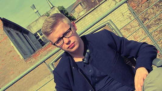 man sitting on gray metal armchair at daytime thumbnail