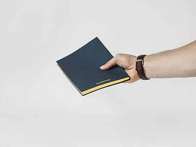 person holding black book thumbnail