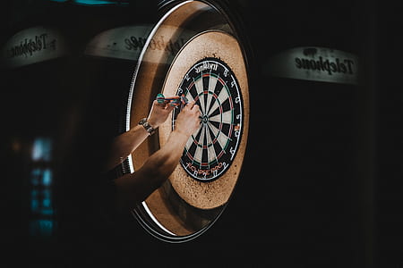 person removing dart pins on dartboard thumbnail