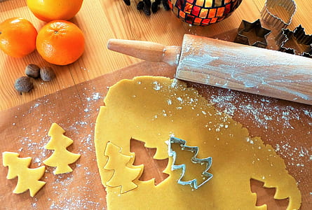 dough cut with Christmas tree form beside rolling pin thumbnail