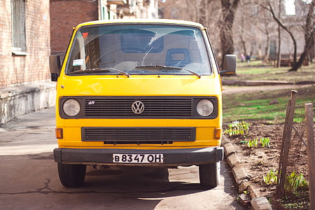 yellow Volkswagen van on road near house at daytime thumbnail