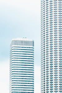 two curtain wall buildings under white sky thumbnail