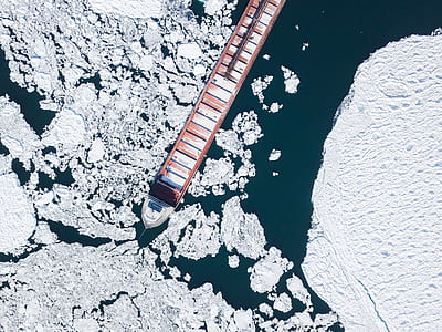 aerial photograph of cargo ship between ice thumbnail