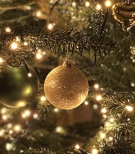 gold glittered bauble on Christmas tree thumbnail