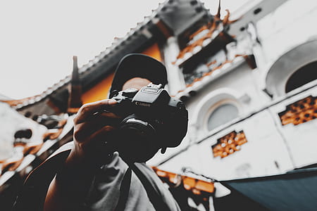 person holding Canon DSLR camera thumbnail