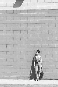 grayscale photo of a woman leaning back on a concrete wall thumbnail