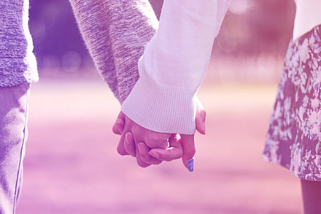 woman and man holding hands during daytime thumbnail
