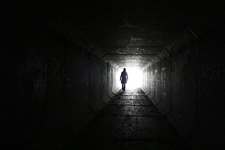 silhouette of a person toward white bright light thumbnail