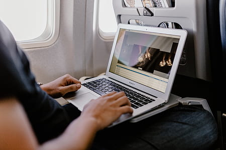 Unrecognizable man with notebook sitting inside an airplane thumbnail