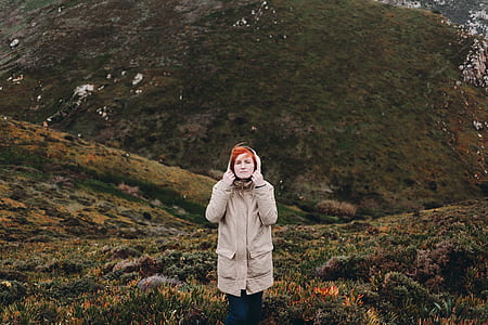 photo of person wearing beige zip-up jacket in the middle of mountain thumbnail