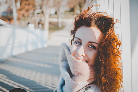 Women Leaning on White Wooden Fence Wearing Gray Furred Top thumbnail