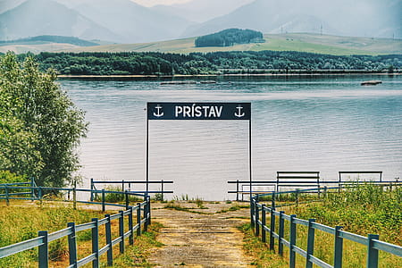 Black Metal Signage Beside Calm Body of Water thumbnail