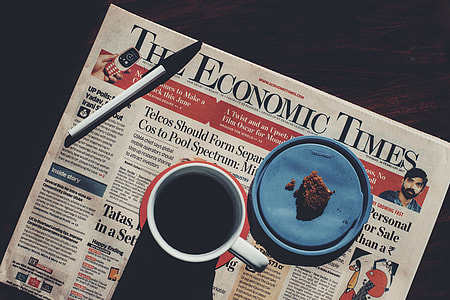 Coffee cup and newspaper on table thumbnail