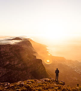 man standing on mountain cliff thumbnail