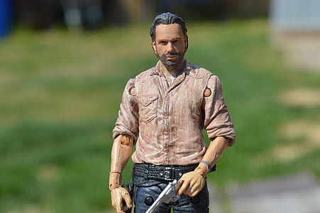man wearing red button-up dress shirt while holding revolver figure thumbnail