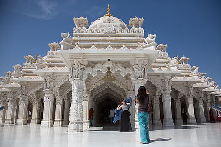 woman taking photo behind white concrete castle at daytime thumbnail