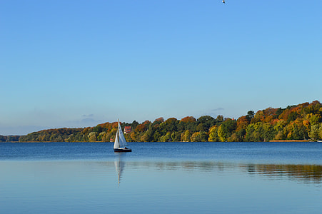black and white sail boat on body of water thumbnail