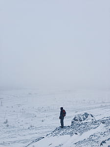 person standing on mountain cliff covered thumbnail
