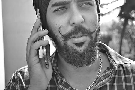 Grayscale Portrait Photo of Man Holding Phone thumbnail