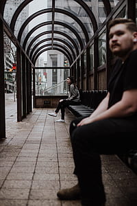 shallow focus photography of woman sitting on bench near man thumbnail