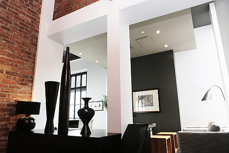 three black vases on top of black wooden furniture beside white column thumbnail