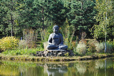 Gautama Buddha statue in front of calm body of water thumbnail