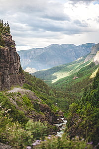 river surrounded by green leaf trees and plants in front of mountain view photography thumbnail