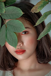 Close-Up Photography of a Woman Near Leaves thumbnail