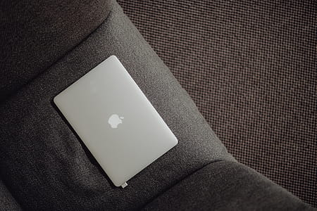 Close up view of closed laptop lying on grey armchair thumbnail