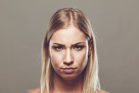 woman with blonde hair near gray wall thumbnail