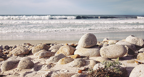 gray concrete rocks near body of water under gray sky thumbnail