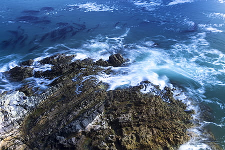 aerial photo of blue seawave near rocks thumbnail