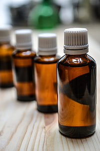 selective photography of four amber bottles with white lid on top of brown wooden surface thumbnail