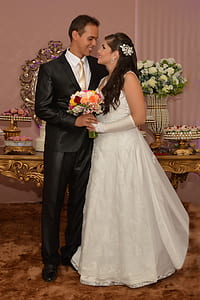 newlywed couple standing near white petaled flower centerpiece thumbnail