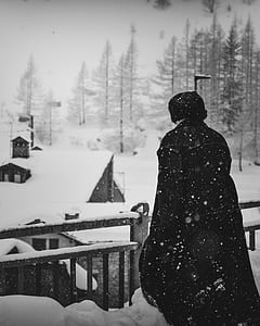 grayscale photo of person standing under snow thumbnail
