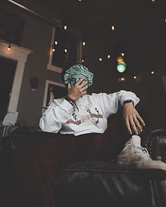 person holding mask sitting on leather sofa thumbnail