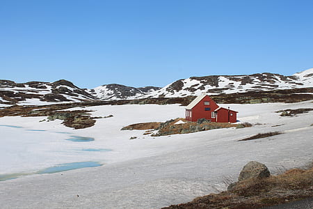 red bard beside body of water and mountains at daytime thumbnail