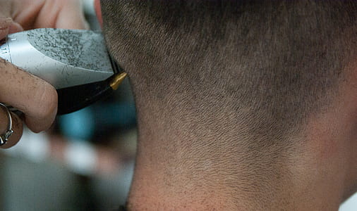 person holding gray and black hair trimmer on head thumbnail